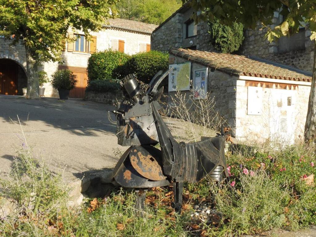 a statue of a machine in front of a building at Gîte Amour D&#39;ardèche in Saint-Sernin
