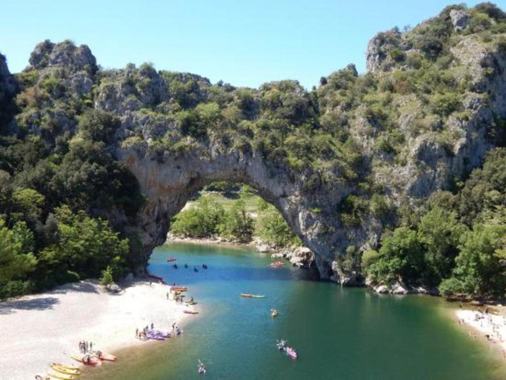 a group of people on a beach in a river at Gîte Amour D&#39;ardèche in Saint-Sernin