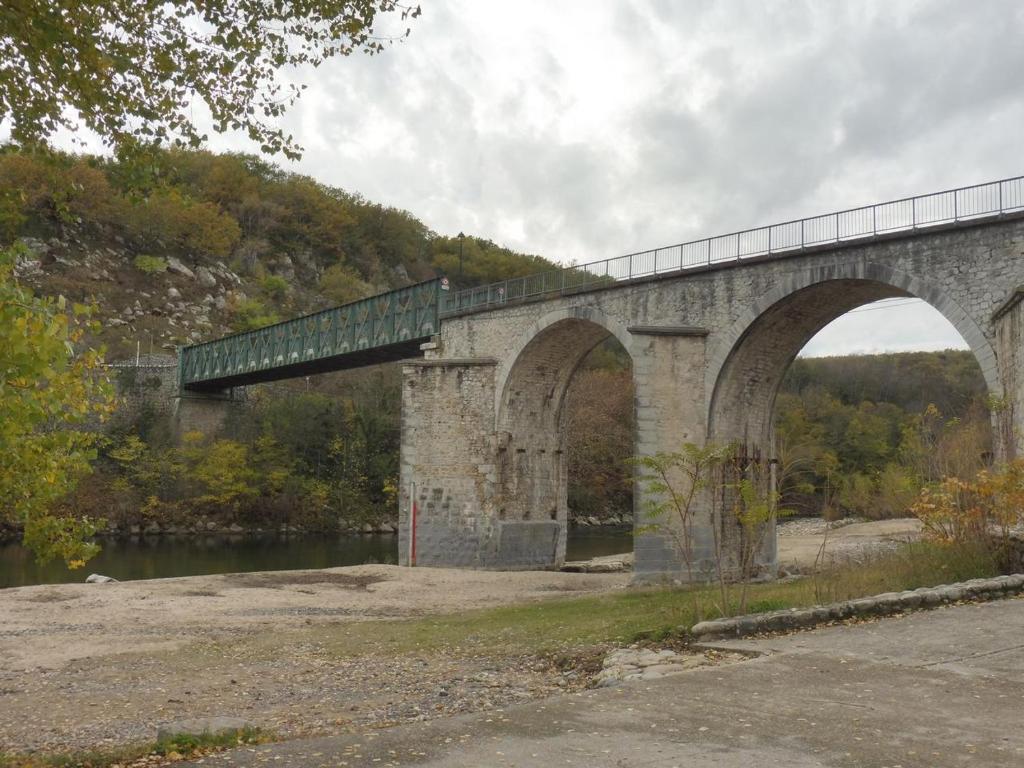 a bridge over a river with a train on it at Gîte Amour D&#39;ardèche in Saint-Sernin