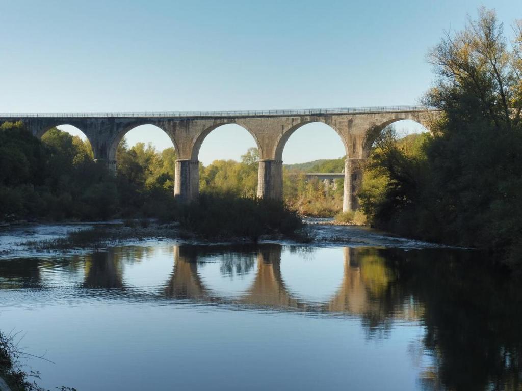 a bridge over a river with a bridge in the background at Gîte Amour D&#39;ardèche in Saint-Sernin