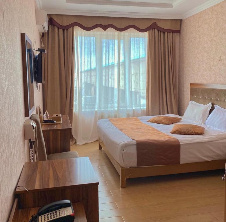 pokój hotelowy z łóżkiem i dużym oknem w obiekcie Royal_hotel_hostel w mieście Aktobe