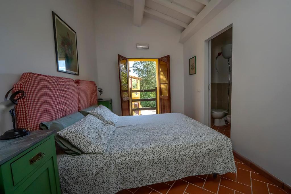 a bedroom with a bed with a green cabinet and a door at Agriturismo La valle in Peccioli