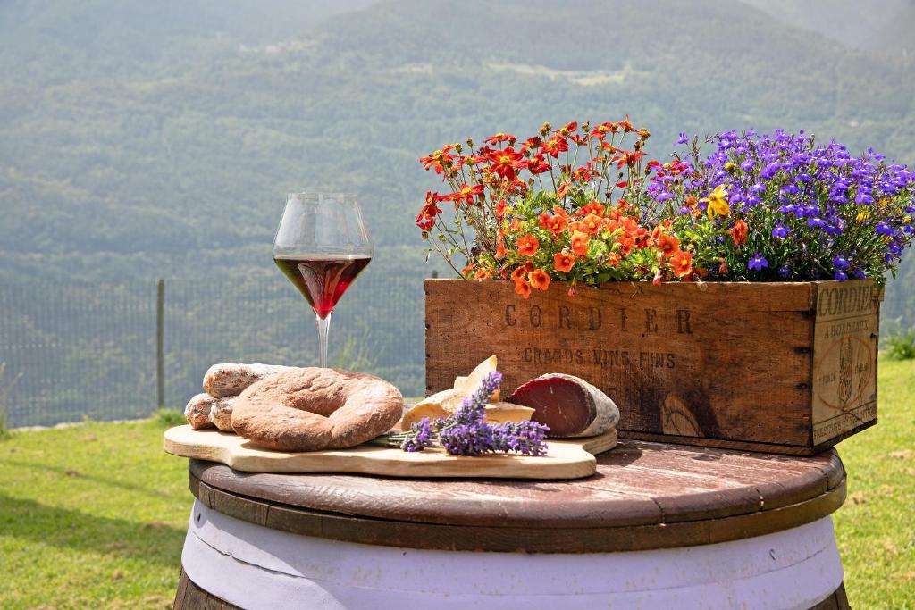 - une table avec un verre de vin et des fleurs dans l'établissement Il posto al sole, à Teglio