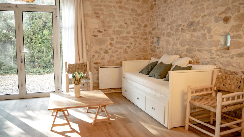 een slaapkamer met een wit bed en een tafel bij La Vigne Blanche Gîtes in Lamotte-du-Rhône