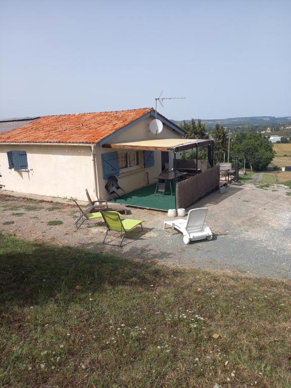 a house with a picnic table and chairs in front of it at Gites panoramique in Sainte-Livrade-sur-Lot