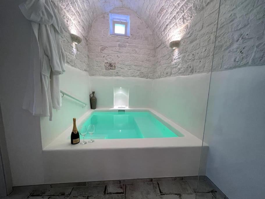 una vasca da bagno con acqua verde in camera di SUITE - Trullo Relax sul Monte a Cisternino