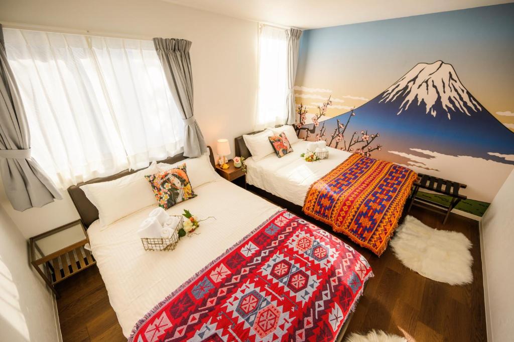 two beds in a room with a mountain mural on the wall at Tokyo Private villa/near station/Ginza/Asakusa/Sky Tree/Louis House in Tokyo