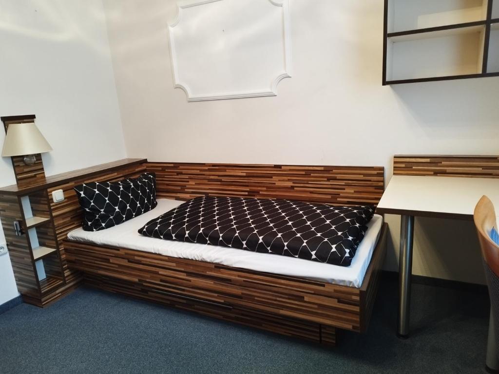 uma pequena cama num quarto com uma secretária em Wohnung - zur Länd em Moosburg