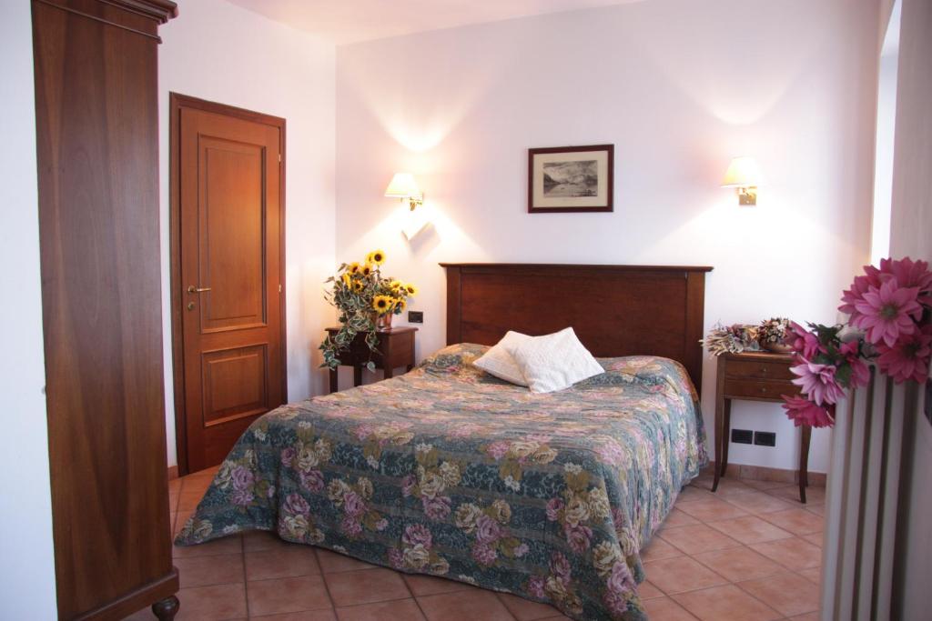a hotel room with a bed and a table with flowers at Hotel La Locanda in Stresa