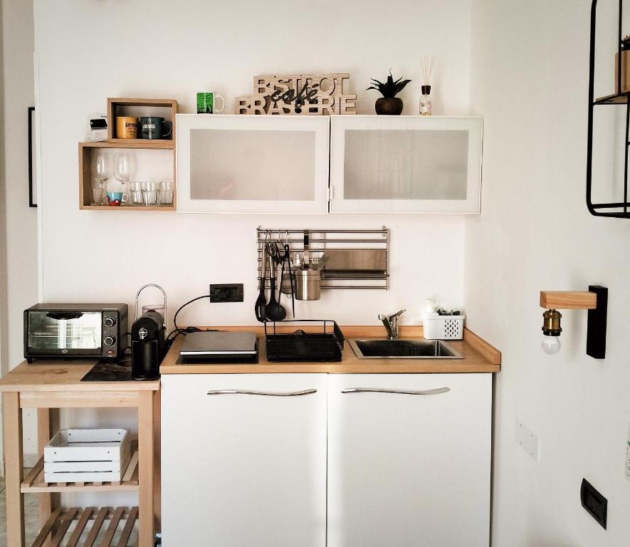 a kitchen with white cabinets and a counter top at Petracca Guest House in Monopoli