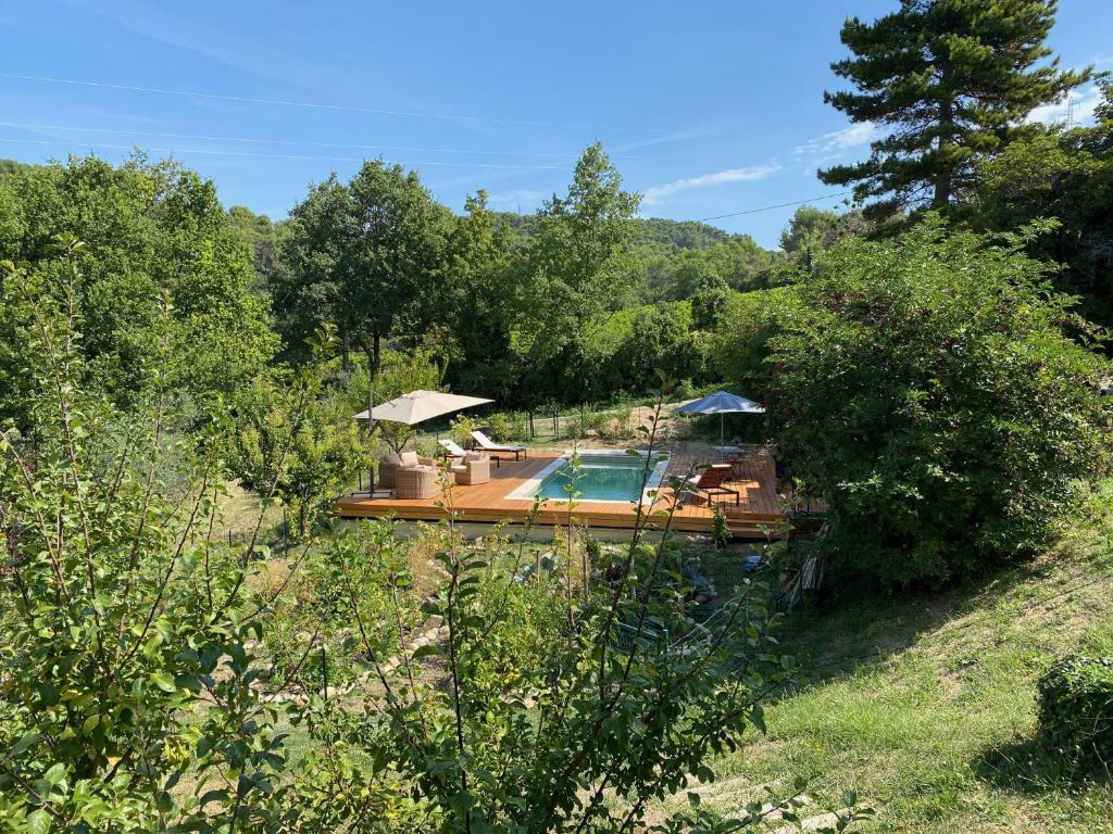 ein Haus mit einem Pool auf einem Feld mit Bäumen in der Unterkunft Otarkia in Vaison-la-Romaine