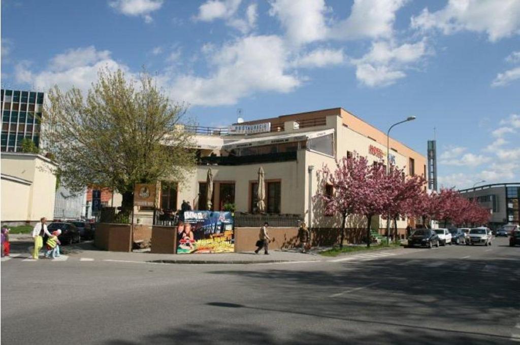 um prédio numa rua com pessoas andando na rua em Hotel Oko em Nitra