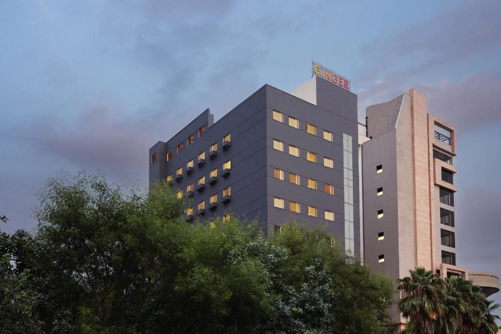 a tall building with a hotel sign on top of it at Ginger East Delhi in New Delhi