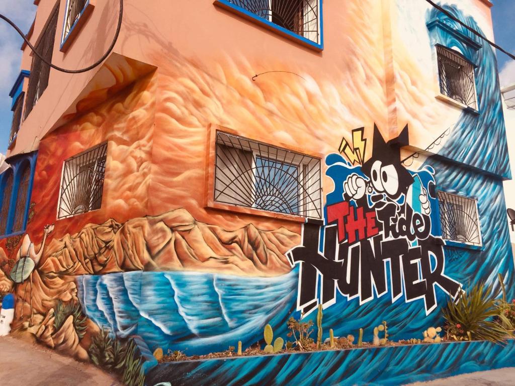 un mural pintado en el lateral de un edificio en Tidehunter Surf House, en Imsouane