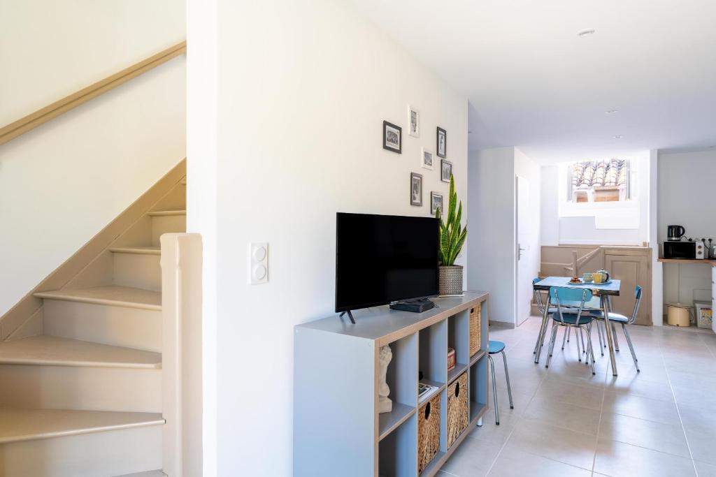 ein Wohnzimmer mit einem TV und einer Treppe in der Unterkunft Appart Casa Zio Vaison la Romaine in Vaison-la-Romaine