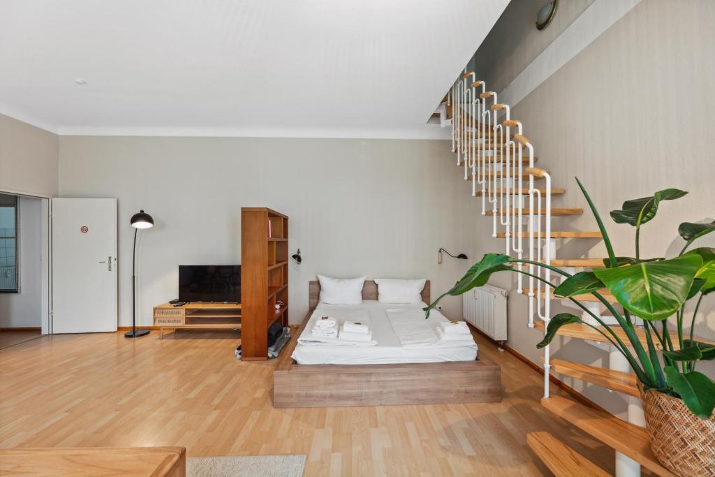 - un salon avec un lit et un escalier dans l'établissement Arbio I 1A Rooms & Apartments Prenzlauerberg Berlin, à Berlin