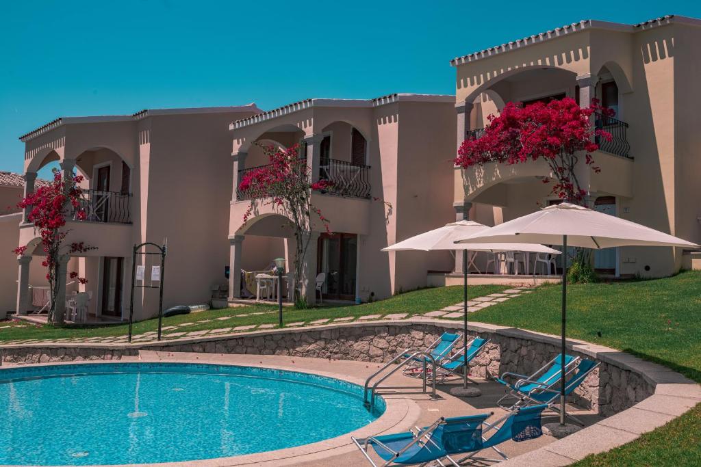 バデージにあるThe Fantastic Residenza Badus two bedroom sleeps sixのスイミングプール、椅子2脚、パラソルが備わるヴィラです。