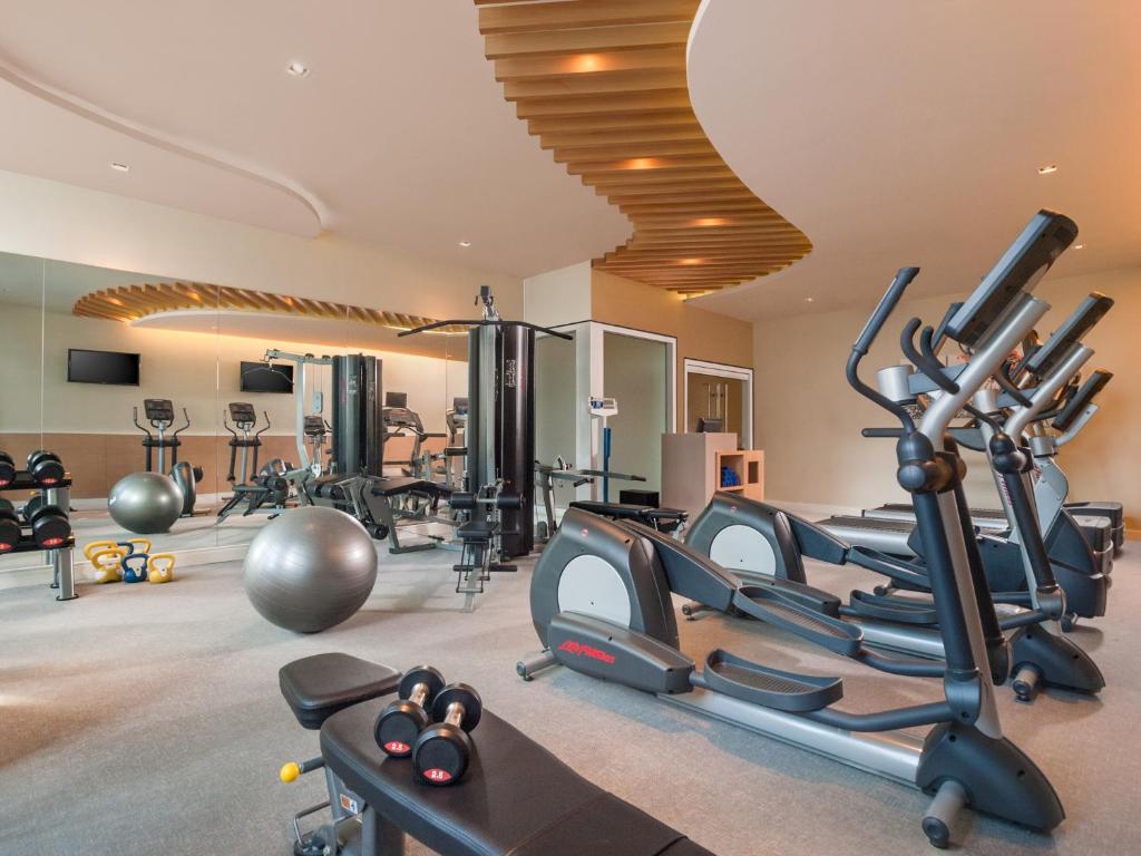 a gym with treadmills and ellipticals in a room at Citadines Salcedo Makati in Manila