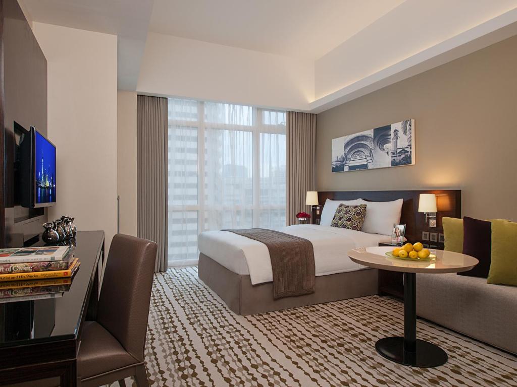 a hotel room with a bed and a table and a couch at Citadines Salcedo Makati in Manila