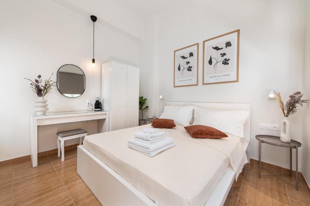 a white bedroom with a white bed and a mirror at Fani's City Apartment in Rhodes Town