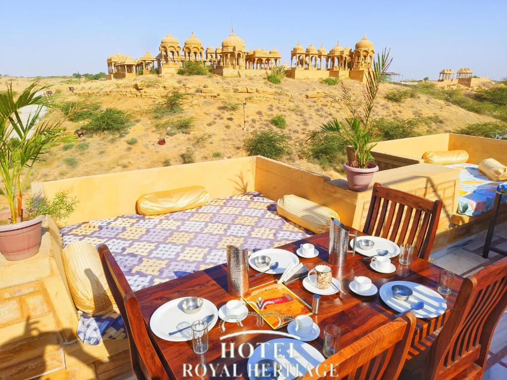 een tafel met borden met eten erop met uitzicht op een woestijn bij Hotel Royal Heritage in Jaisalmer