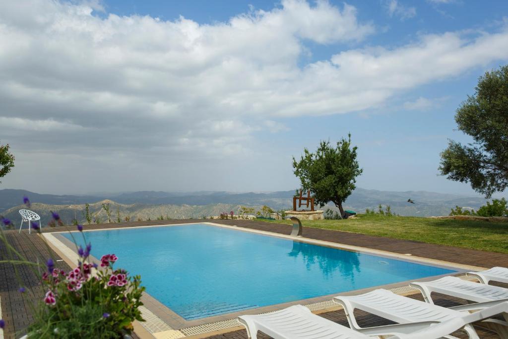 una piscina con sillas y vistas a las montañas en LuimarVenue, en Pano Lefkara