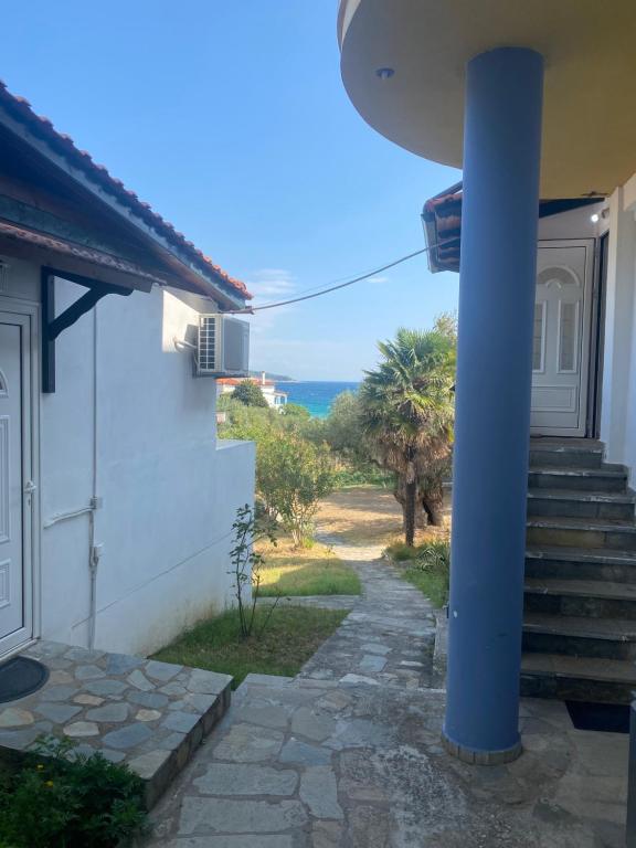 a house with a blue pole next to a door at Blue Bay Beach Hotel in Koinyra
