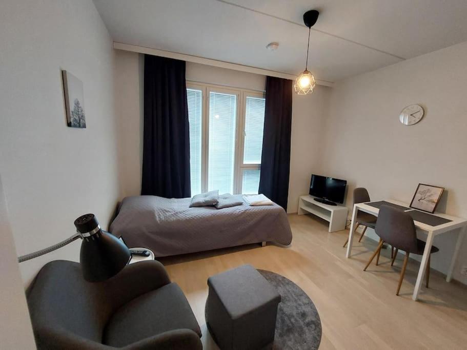 een slaapkamer met een bed, een bureau en een stoel bij Kotimaailma Apartments Vapaudenkatu 48-50 B3 in Jyväskylä