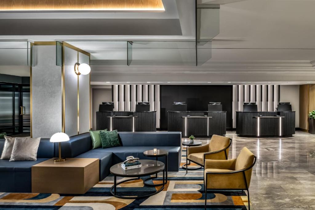 a lobby with a blue couch and chairs at Le Centre Sheraton Montreal Hotel in Montreal