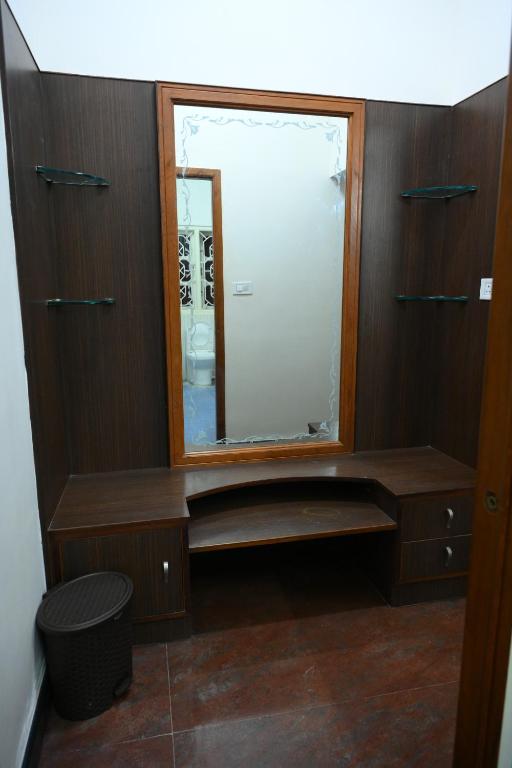 ハッサンにあるAmayaa Courtyard Homestayのバスルーム(鏡、木製キャビネット付)