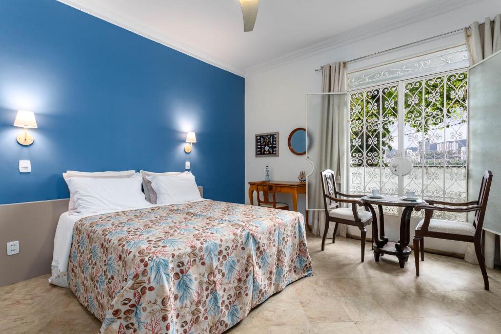 a bedroom with a bed and a table and a window at STUDIOS URCA na rua da mureta da Urca in Rio de Janeiro