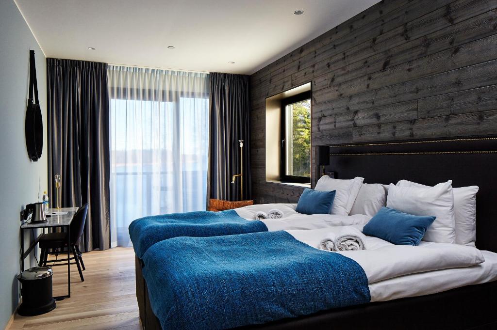 1 Schlafzimmer mit 2 Betten und blauen Kissen in der Unterkunft Marholmen in Norrtälje
