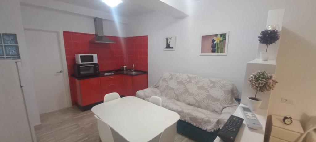 sala de estar con silla y pared roja en Antonio Fernández Playa, en Conil de la Frontera