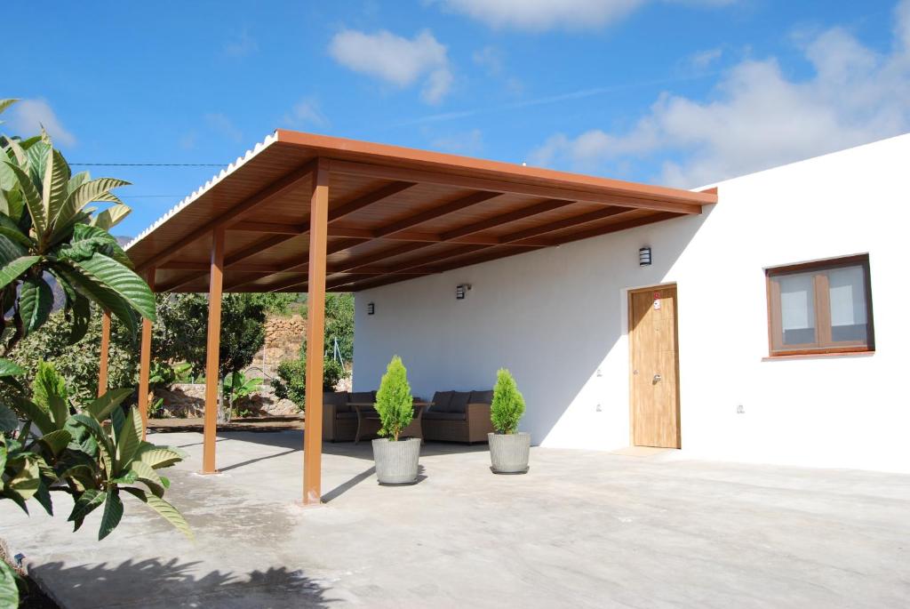 a white house with a wooden pergola at Casa El Cuarto con preciosas vistas en Candelaria in Candelaria