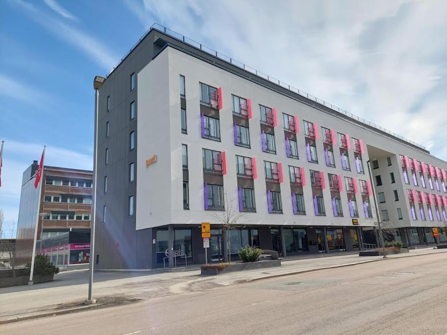 un gran edificio con ventanas rojas y blancas en una calle en Kotimaailma Apartments Vapaudenkatu 48-50 B9, en Jyväskylä