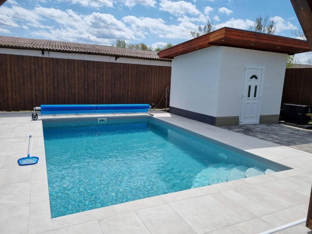 a swimming pool in a backyard with a wooden fence at Finfera Villa in Balatonboglár