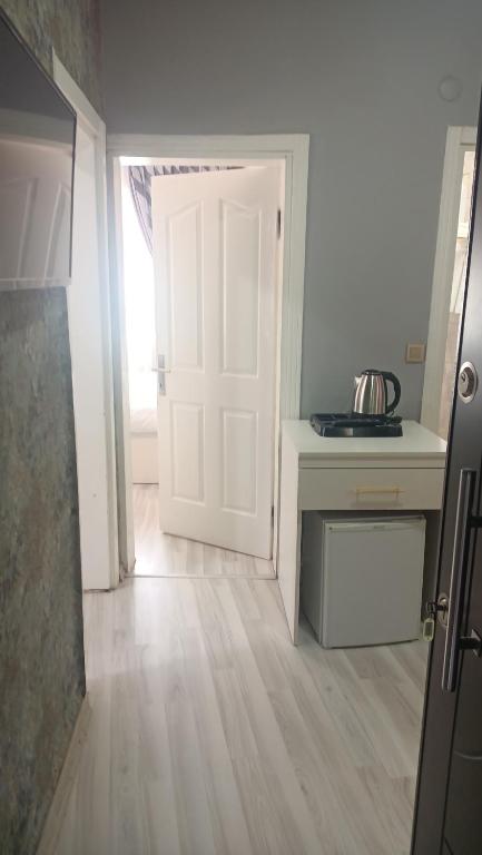 cocina con puerta blanca y suelo de madera en Fetih Suite Home A1 en Estambul