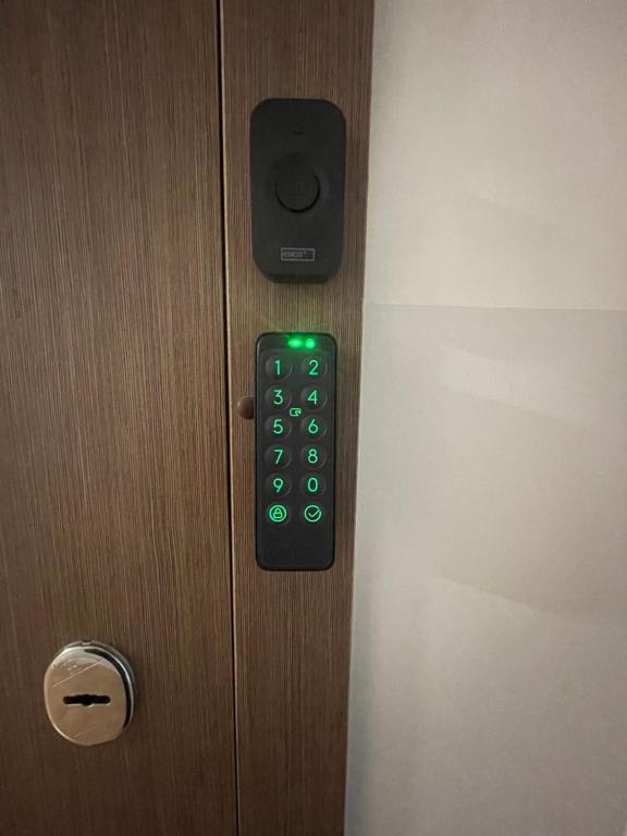um controlo remoto numa porta com luz verde em Ukmergė Apartments em Ukmergė