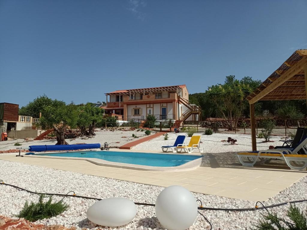 um resort com uma piscina e uma casa em B&B Casa Flamenga em Alte