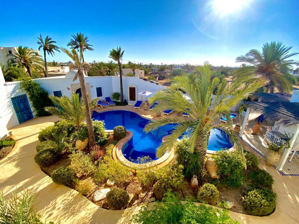 an aerial view of a house with a swimming pool and palm trees at Dar Aladin in Arkou