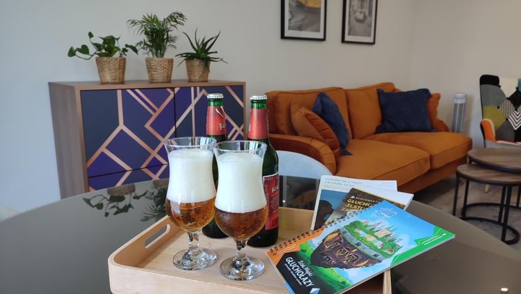 two glasses of beer on a table in a living room at APARTAMENT "Opawska Przystań" in Głuchołazy