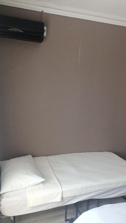 een bed in een kamer met een witte muur bij Fetih Suite Home A2 in Istanbul