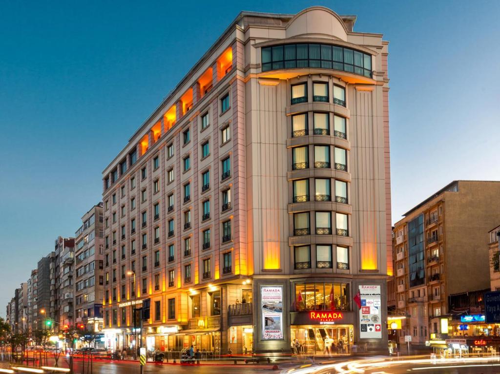 Ramada Plaza By Wyndham Istanbul City Center في إسطنبول: مبنى طويل على شارع المدينة في الليل