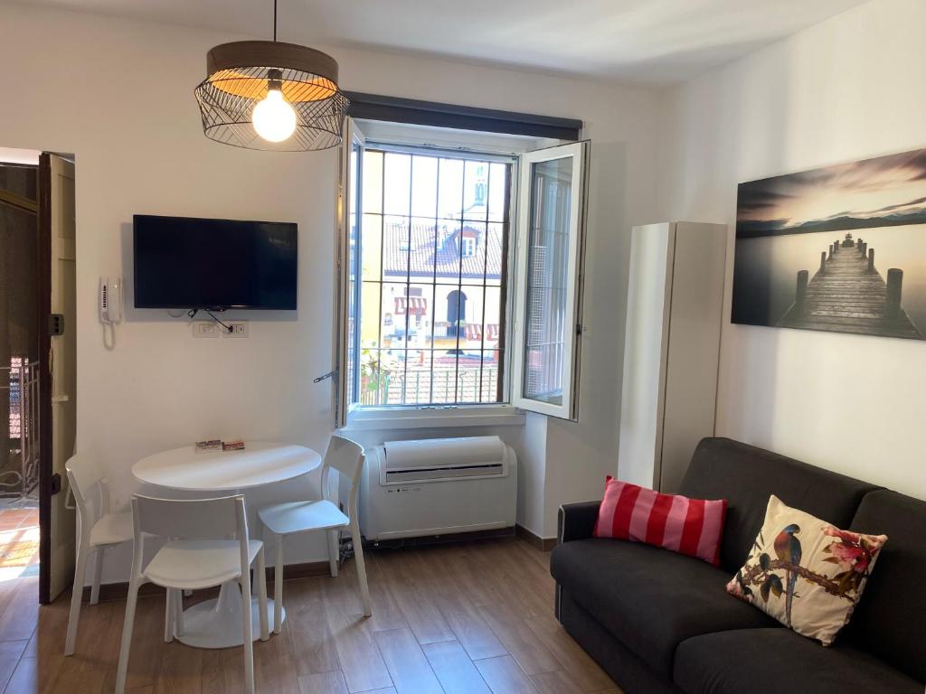 una sala de estar con un sofá y una mesa en Casale 7- Navigli Cozy Studio perfect x2!, en Milán