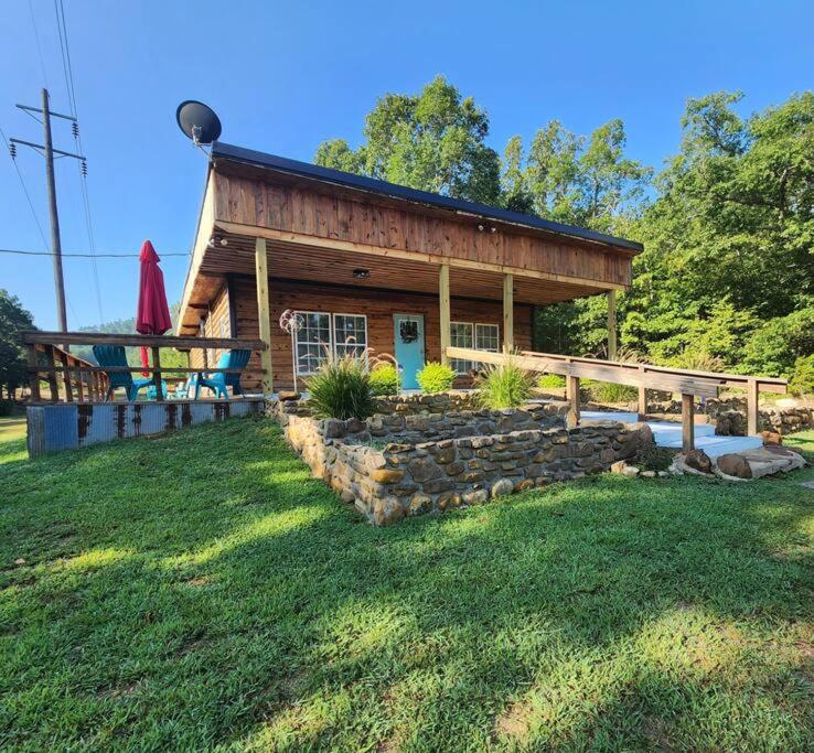 eine Blockhütte mit einer Steinmauer im Hof in der Unterkunft Unique Country Cabin Meets Farmhouse Modern!!! in Mena