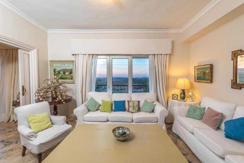 a living room with two white couches and a table at Casa en la Corredera in Vejer de la Frontera