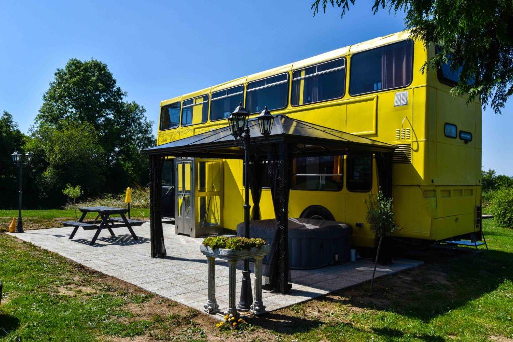 a yellow double decker bus parked in a park at The Big Yellow Bus in Montchevrier