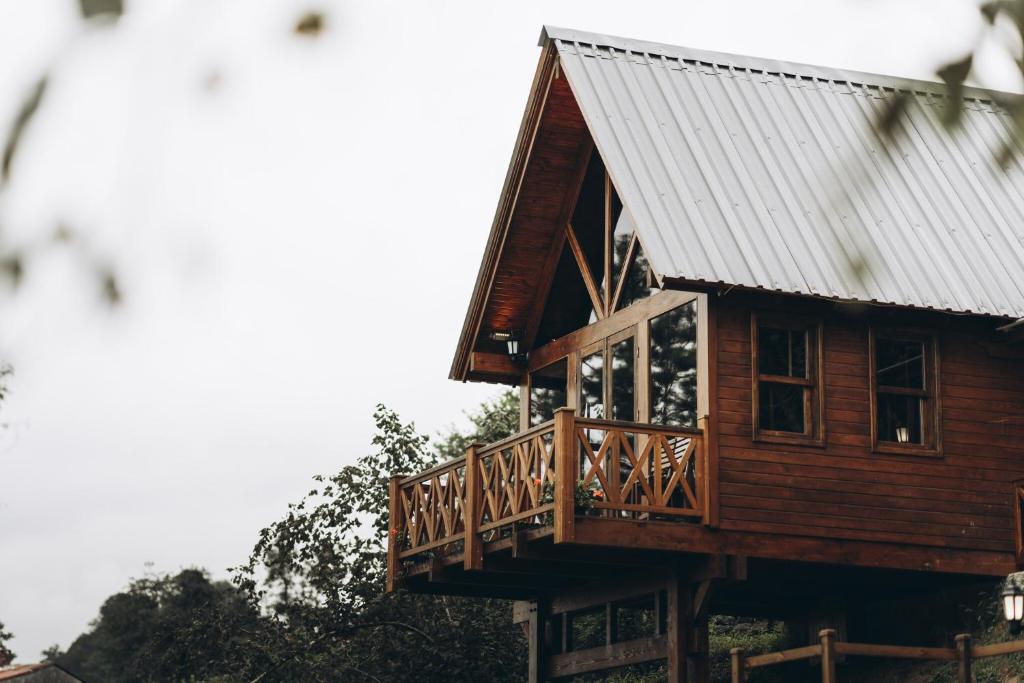 Cabaña de madera con balcón y techo de metal en Lome Çiftliği Otel ve Restoran en Artvin