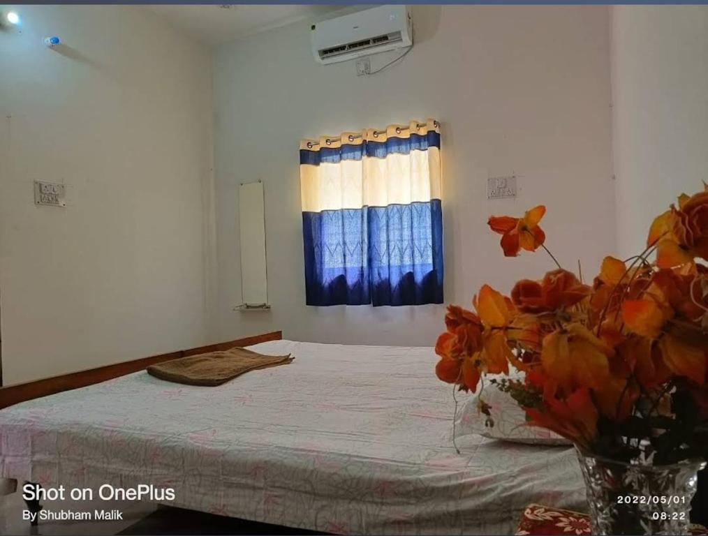 a bedroom with a bed and a vase of flowers at Hotel Ashirwad Palace in Rajaun