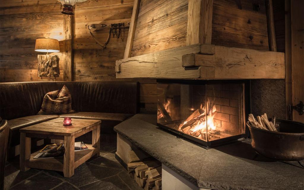 een open haard in een kamer met een bank en een tafel bij Alpenclub in Engelberg